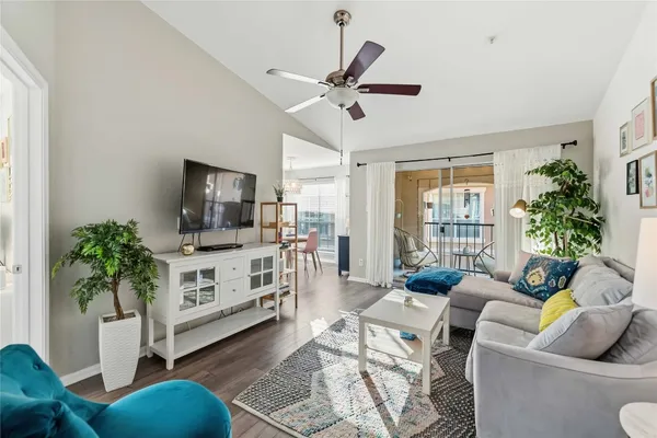 a living room with furniture a flat screen tv and a potted plant