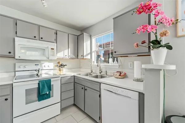 a kitchen with a sink and a stove next to a white cabinet