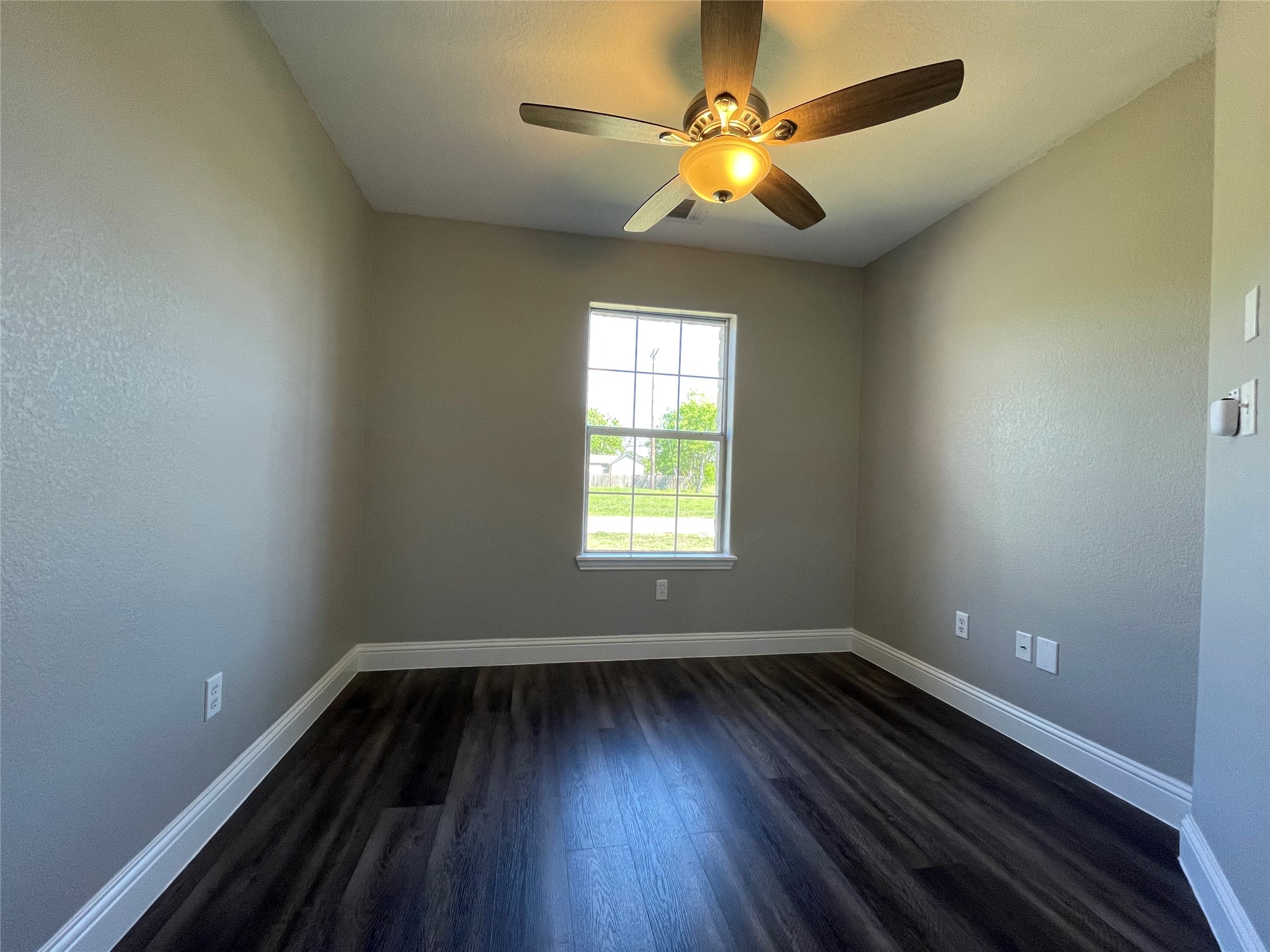 2004 Maple Street Georgetown, TX 78626 - Photo 18 of 31 Neutral tone walls with white trim, wood-finish flooring, and a ceiling fan with integrated lighting