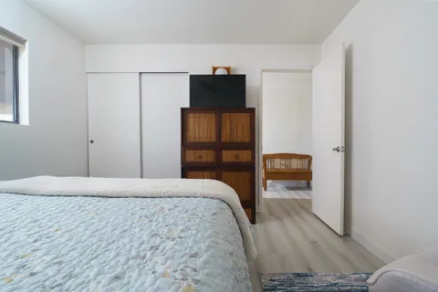 a bedroom with a bed a mirror and a window