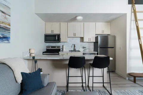 a kitchen with stainless steel appliances granite countertop a refrigerator and a stove top oven