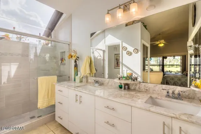 a bathroom with a double vanity sink mirror and shower