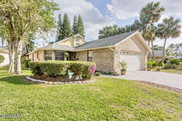a front view of a house with a yard and potted plants