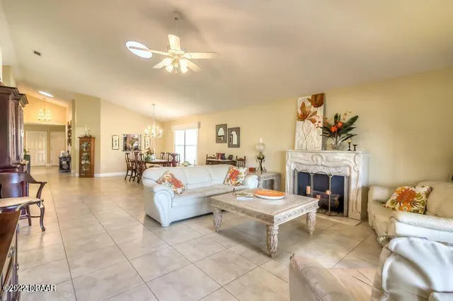 a living room with furniture a fireplace and a chandelier