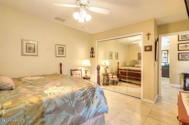 a spacious bedroom with a bed and ceiling fan