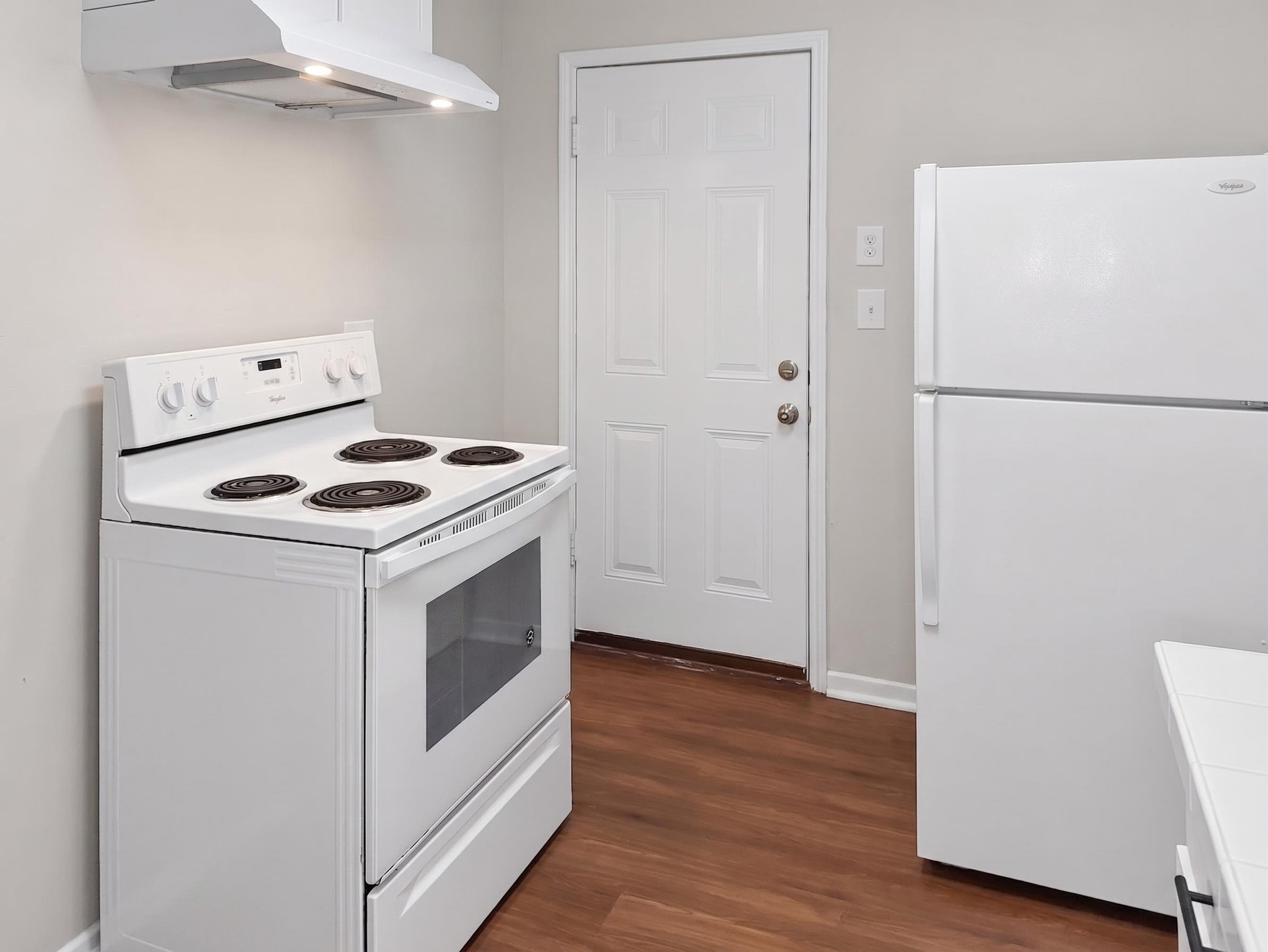 2313 Avenue L Rosenberg, TX 77471 - Photo 14 of 31 Kitchen featuring an electric range, vent hood, refrigerator, and durable flooring with easy access to the back entry.