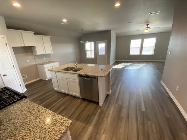 a kitchen with a sink stove and wooden floor