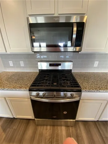 a stove top oven sitting inside of a kitchen