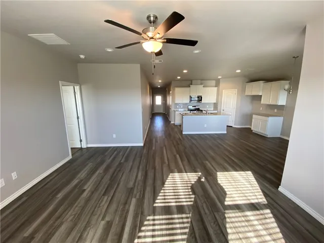 a view of a living room and kitchen with furniture wooden floor