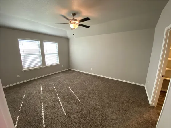 an empty room with windows and fan