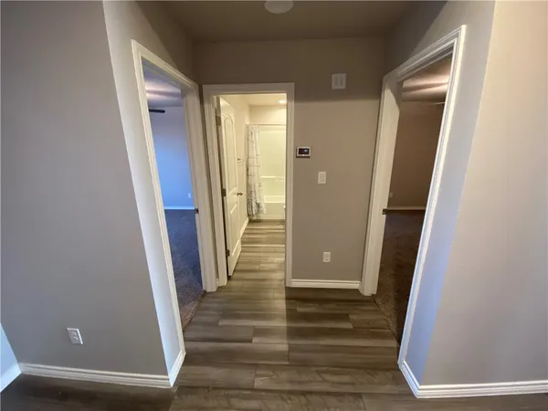 a view of a hallway with wooden floor and staircase