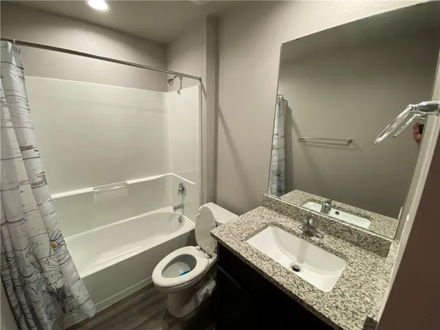a bathroom with a granite countertop sink toilet and shower