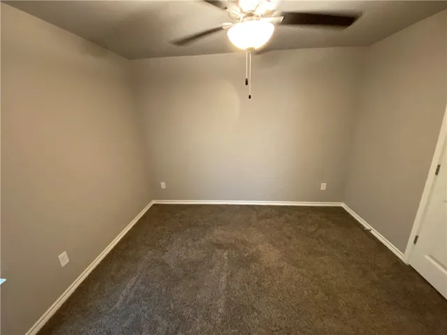 an empty room with a chandelier fan