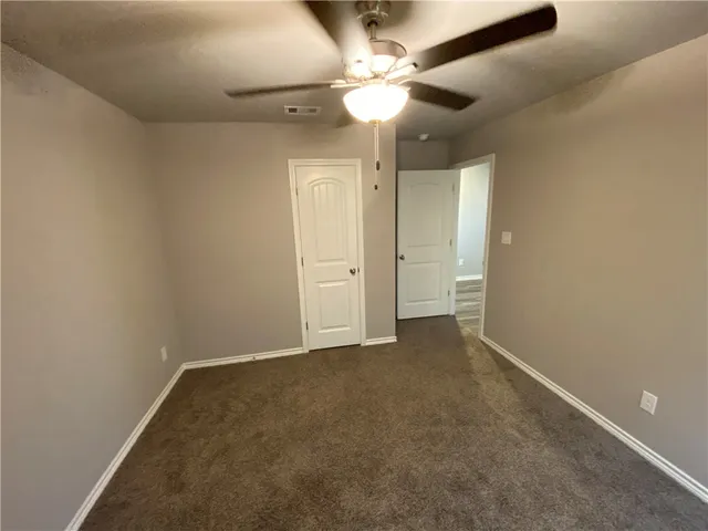 en empty room with windows and fan