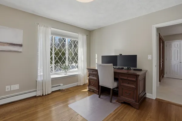 a view of a workspace with furniture and a window