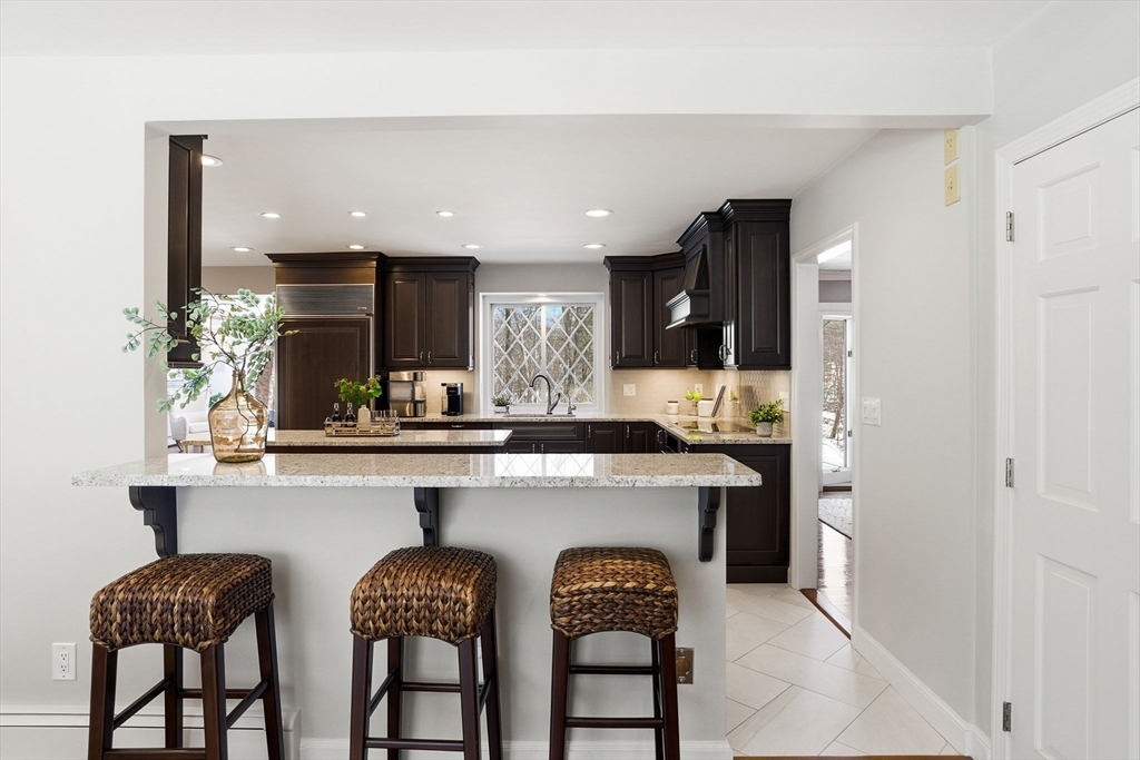 10 Bridle Path North Andover, MA 01845 - Photo 10 of 42 a kitchen with white cabinets and chairs