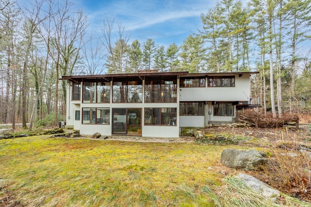 88 Heald Road Carlisle, MA 01741 - Photo 2 of 42 a large pool that has lawn chairs under an umbrella