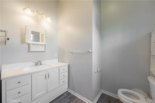 a bathroom with a granite countertop toilet sink and mirror