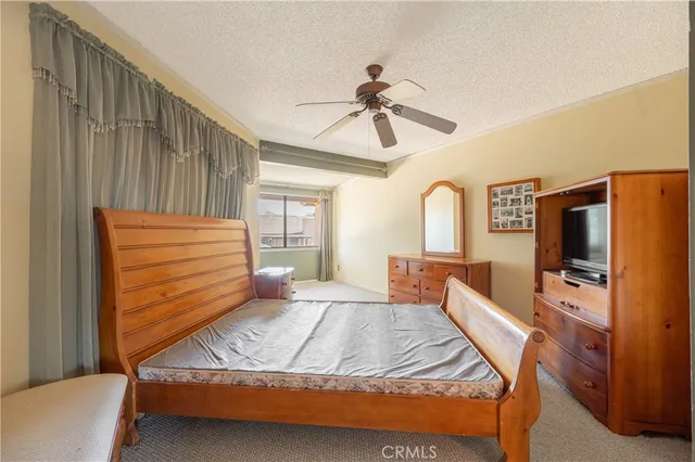a bedroom with a bed and a flat tv screen on the dresser