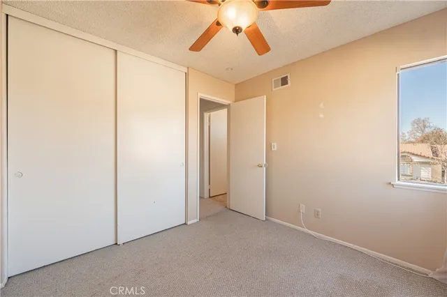 a view of a room with a ceiling fan and refrigerator
