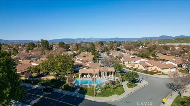 an aerial view of residential houses with outdoor space and trees