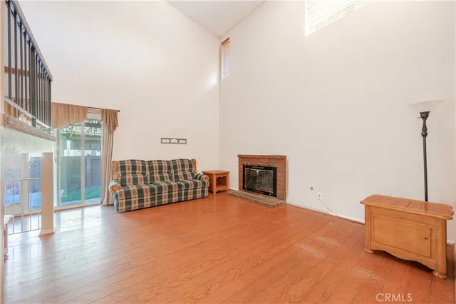 an empty room with floor to ceiling window and fire place