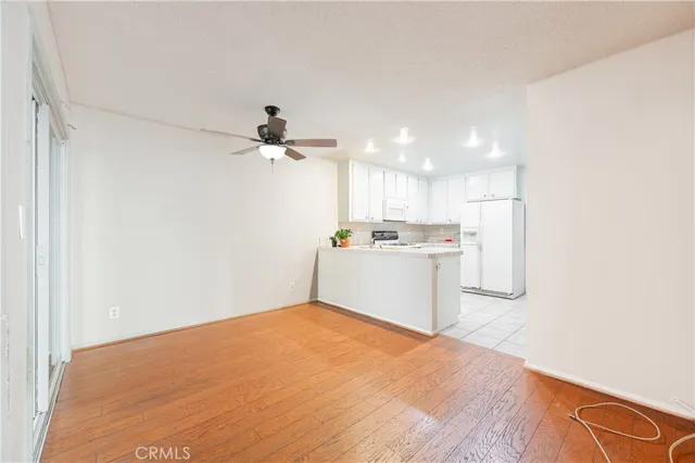 a kitchen with a refrigerator and white cabinets