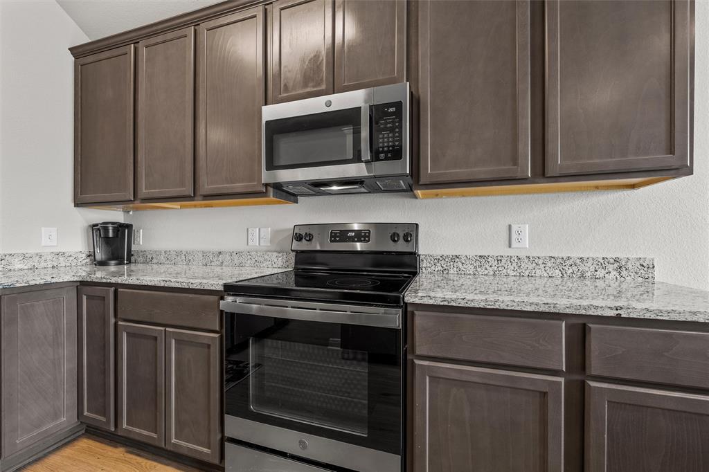 4056 Centerfire Road Waco, TX 76705 - Photo 9 of 27 a kitchen with granite countertop a stove microwave and sink