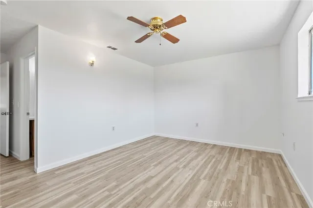 a view of a room with wooden floor and ceiling fan