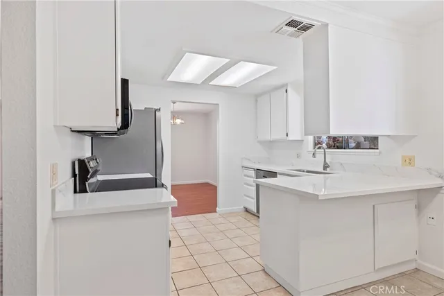 a kitchen with a sink dishwasher a stove a dining table and chairs