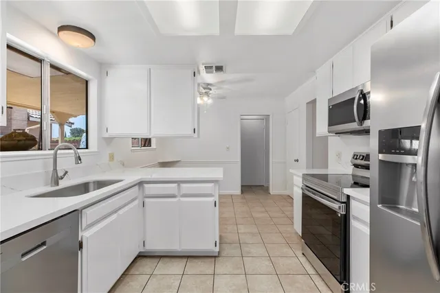 a kitchen with white cabinets appliances and a sink