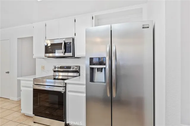 a kitchen with stainless steel appliances a refrigerator stove and microwave