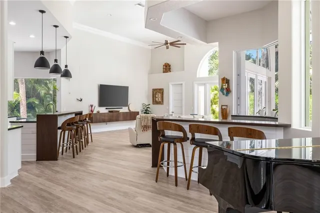 a very nice looking dining room with kitchen island granite countertop a stove top oven a sink and a large window
