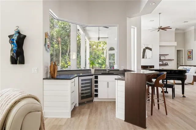 a kitchen with stainless steel appliances granite countertop a stove a sink dishwasher and a dining table with wooden floor