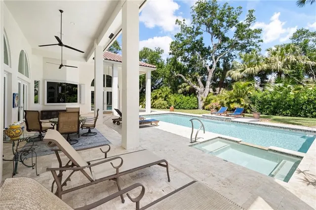 a living room with patio furniture and a potted plant