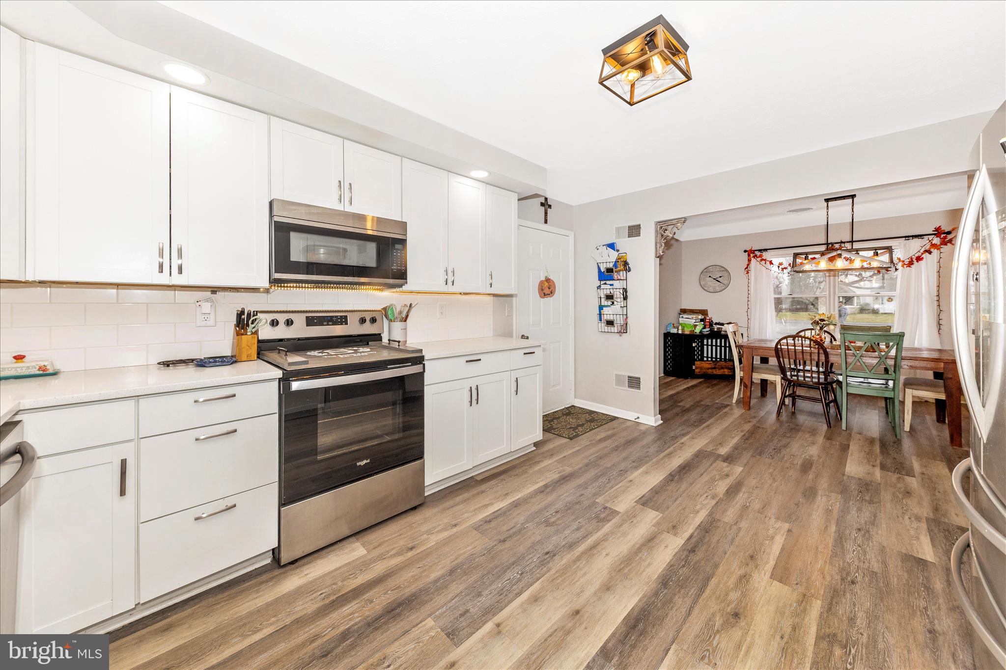 126 Game Trail Road Falling Waters, WV 25419 - Photo 12 of 41 a kitchen with stainless steel appliances a stove top oven a sink dishwasher and a microwave oven with wooden floor