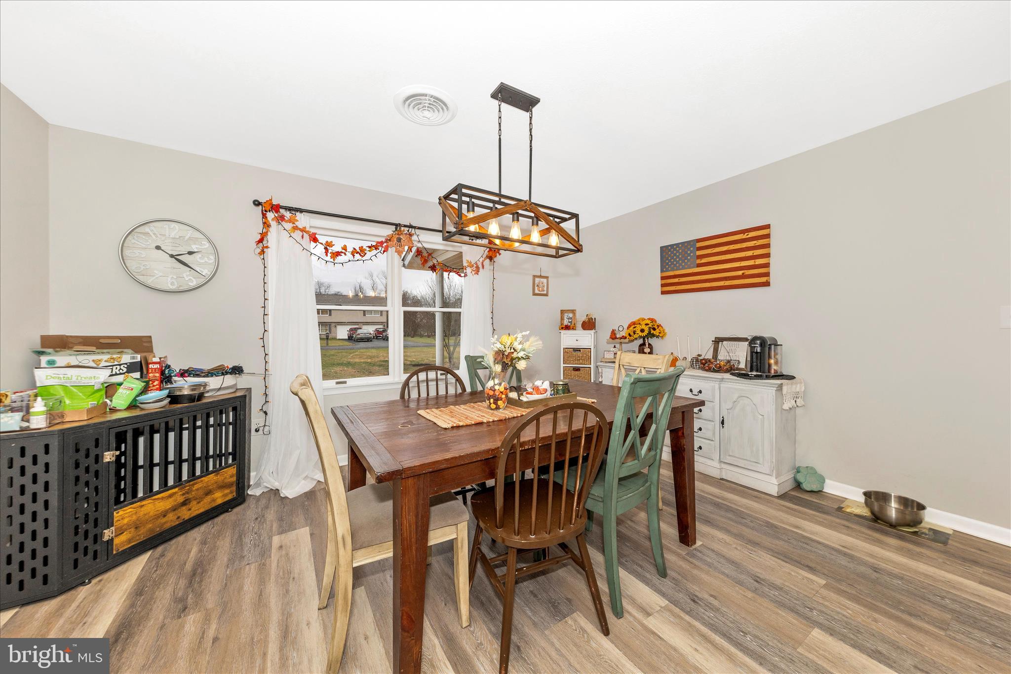 126 Game Trail Road Falling Waters, WV 25419 - Photo 15 of 41 a view of a dining room and livingroom with furniture wooden floor a rug a flat screen tv and a chandelier