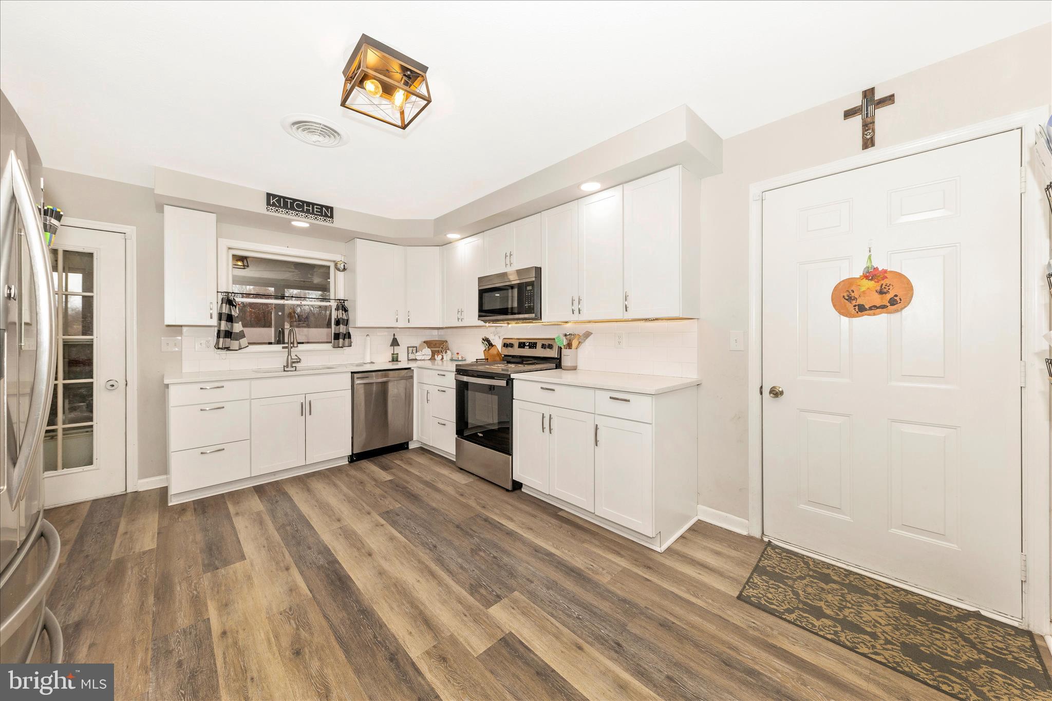 126 Game Trail Road Falling Waters, WV 25419 - Photo 8 of 41 a kitchen with a refrigerator a stove top oven and a sink with wooden floor