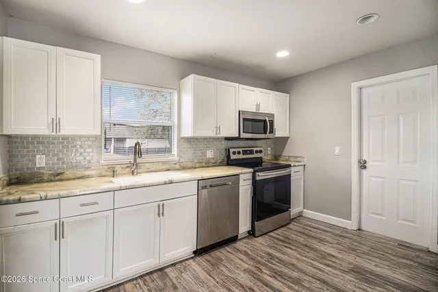 a kitchen with a sink cabinets and stainless steel appliances