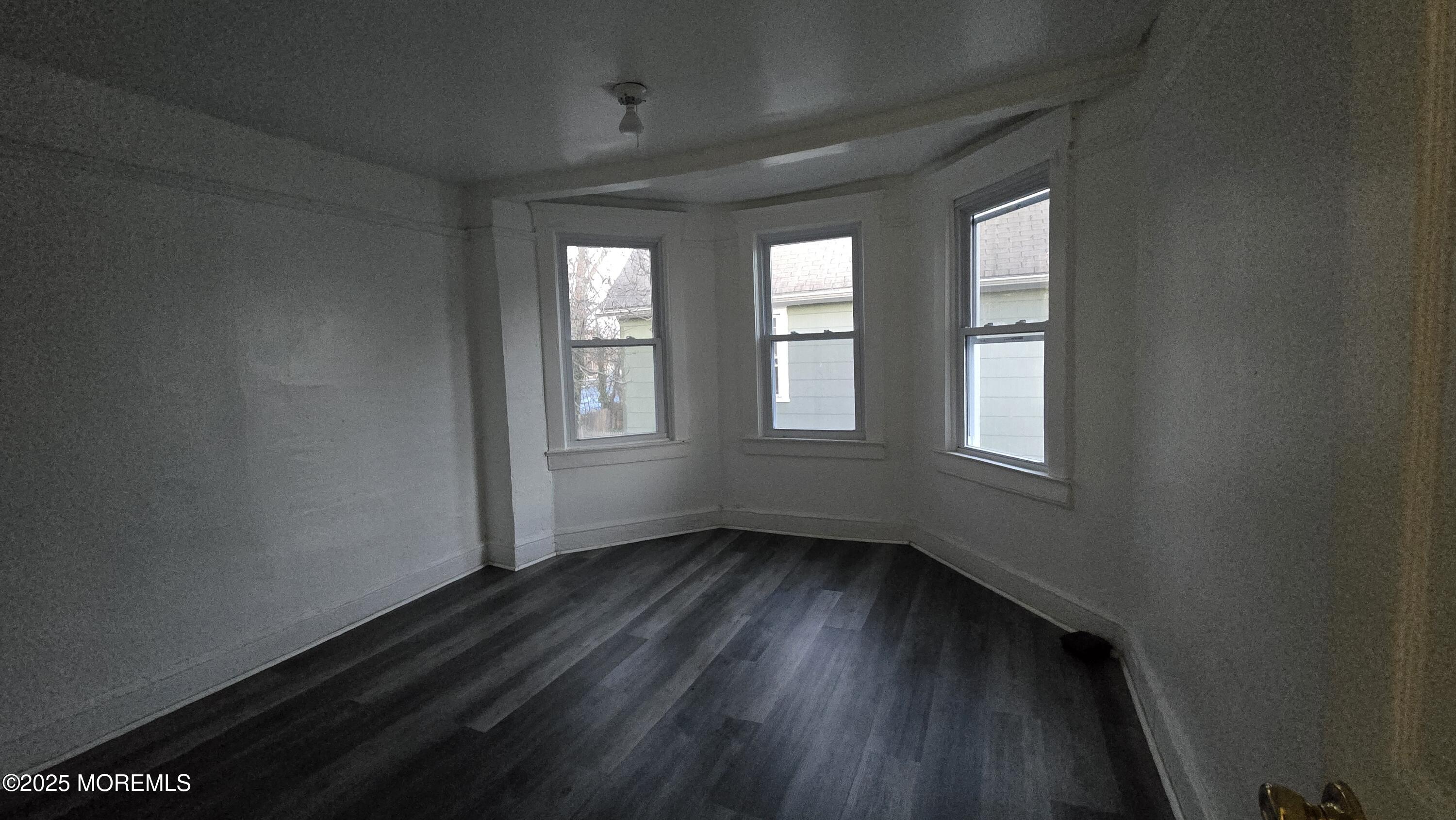 1219 Mattison Avenue, Unit 2 Asbury Park, NJ 07712 - Photo 5 of 11 a view of an empty room with wooden floor and a window