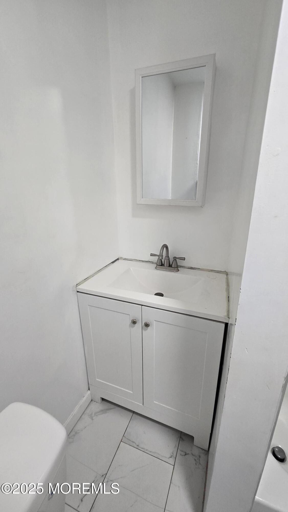 1219 Mattison Avenue, Unit 2 Asbury Park, NJ 07712 - Photo 10 of 11 a bathroom with a sink a toilet and mirror