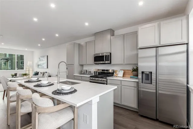 a kitchen with kitchen island granite countertop a sink stainless steel appliances and cabinets
