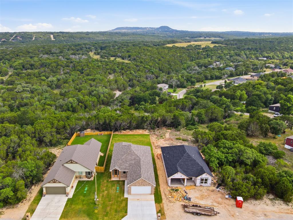 1413 Ridgeview Circle Granbury, TX 76048 - Photo 31 of 35 Aerial perspective showcasing three distinct properties amidst a verdant, tree-filled landscape
