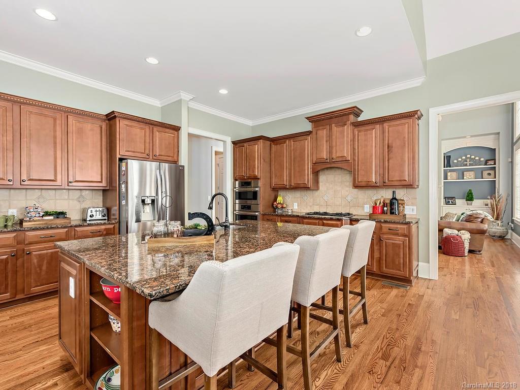 2001 Streamview Court Marvin, NC 28173 - Photo 14 of 35 a kitchen with stainless steel appliances granite countertop a stove top oven a sink dishwasher and white cabinets with wooden floor