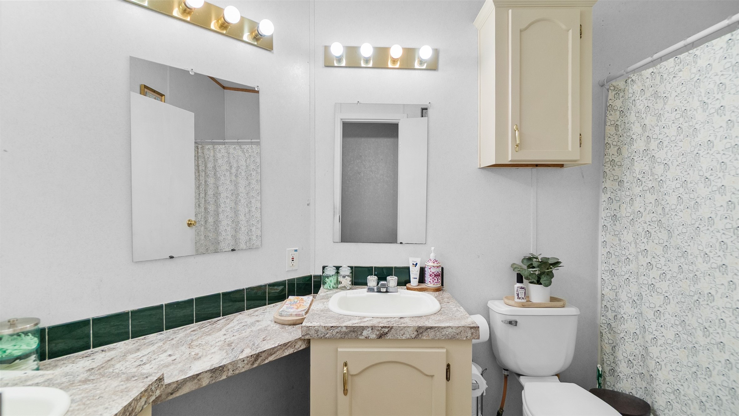 7735 North Walker Road Cleveland, TX 77328 - Photo 32 of 42 a bathroom with a granite countertop sink a toilet and mirror