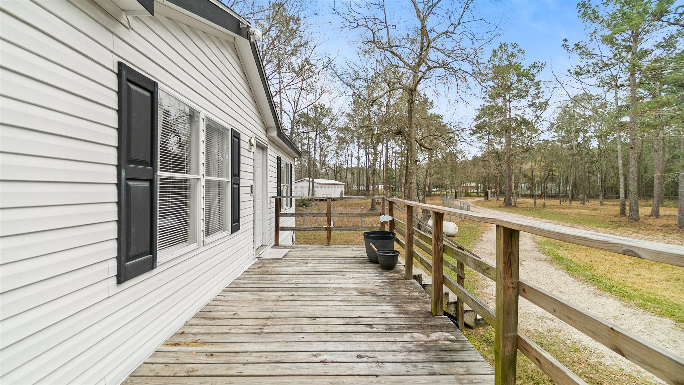 7735 North Walker Road Cleveland, TX 77328 - Photo 35 of 42 a view of a balcony with wooden floor and large trees