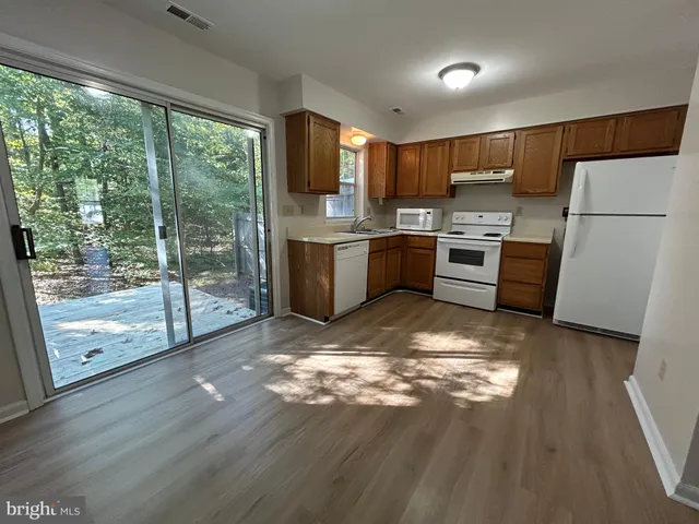 a kitchen with stainless steel appliances granite countertop a refrigerator sink and stove