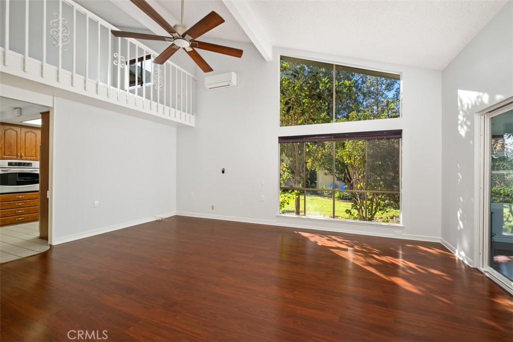 842 Ronda Sevilla, Unit B Laguna Woods, CA 92637 - Photo 3 of 27 an empty room with wooden floor and windows