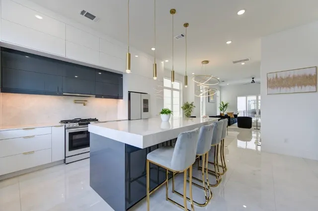 a kitchen with granite countertop a stove a sink and a refrigerator