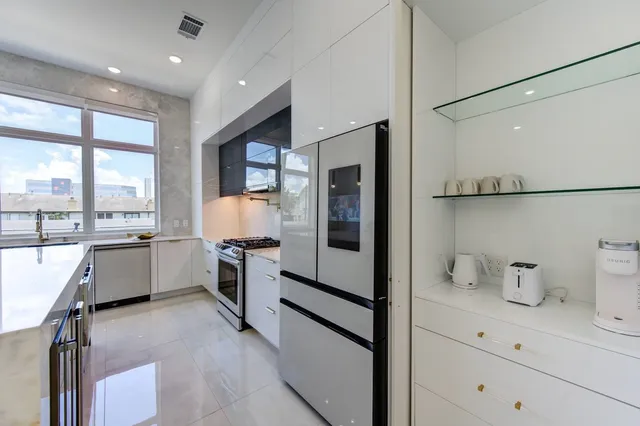 a kitchen with stainless steel appliances a table and chairs in it